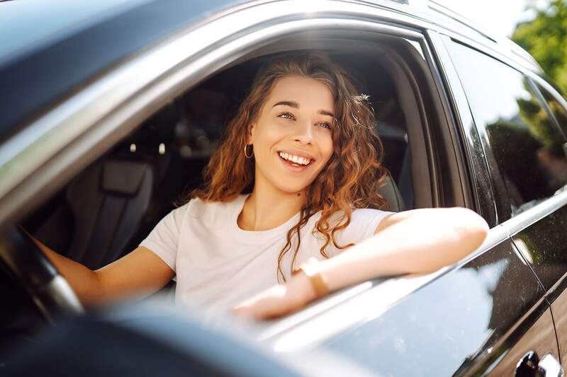 Happy driver using Rainforest FastPass unlimited car wash membership