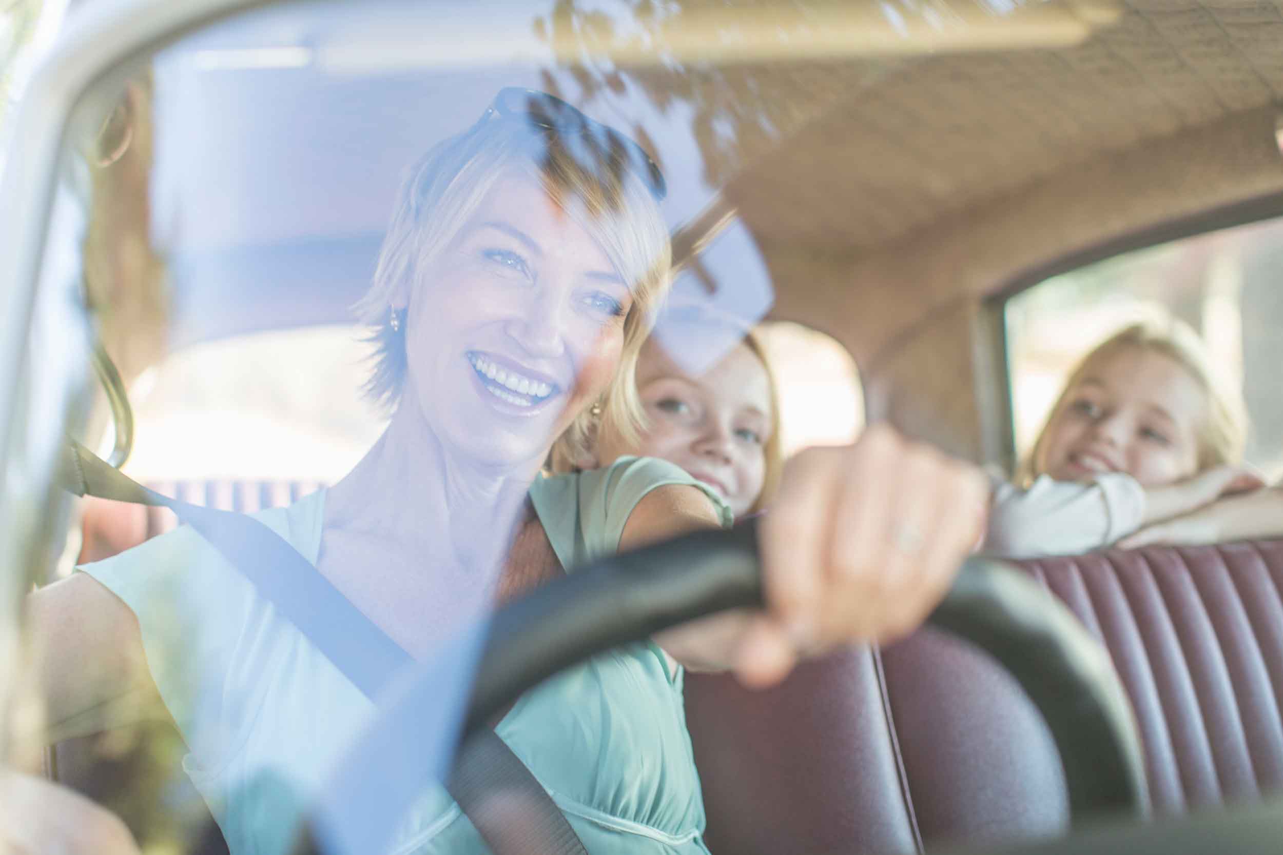 Happy family driving through Rainforest Carwash
